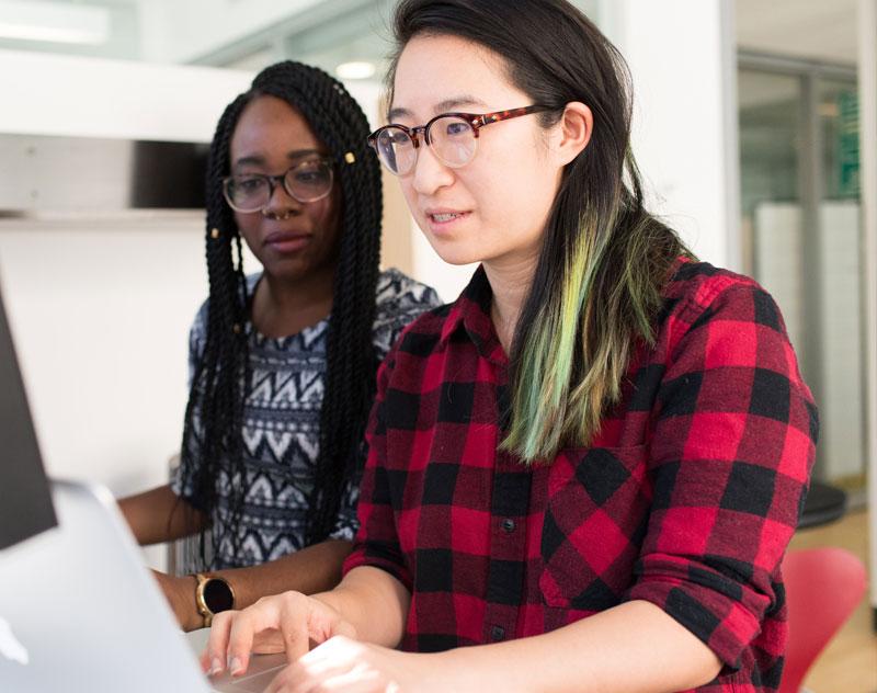 Image shows two people at a computer.